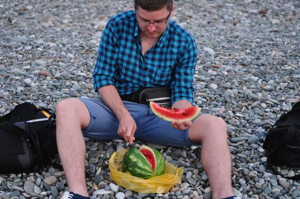 Tomek kroi arbuza na "plaży" w Barumi